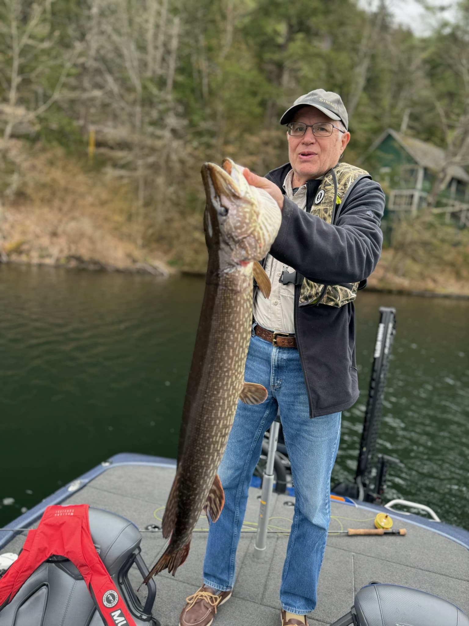 Angler with fly rod pursuing bass in shallow waters